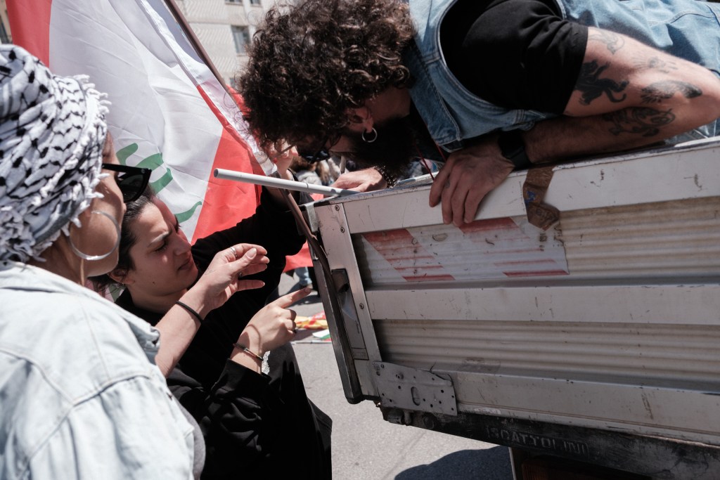 A group sets up a van with a Lebanese flag before the Bari march departs.