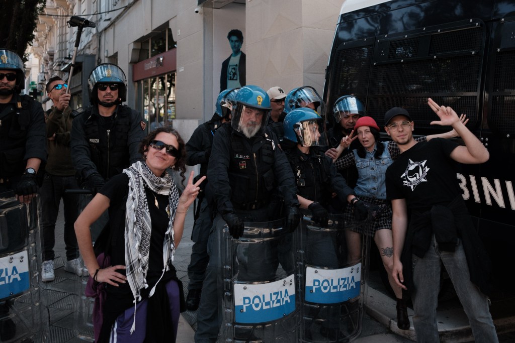 Marchers and police officers pose together, some flashing peace signs, end of the 18 May 2026 march.