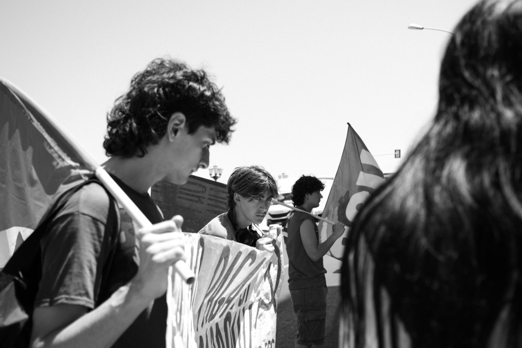 Group of young marchers with flags at Bari's anti-IRPEF demonstration.